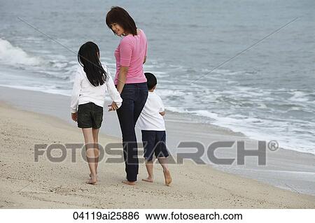 Young woman walking on beach with boy and girl View Large Photo Image Stock Photograph - Young woman walking on beach with boy and girl. Fotosearch