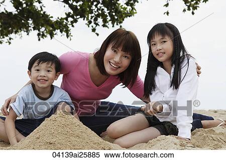 Young woman with boy and girl playing in sand View Large Photo Image Stock Photography - Young woman with boy and girl playing in sand. Fotosearch