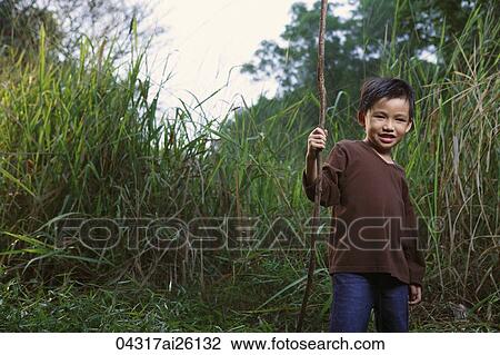 Stock Image - Boy holding stick.. Fotosearch