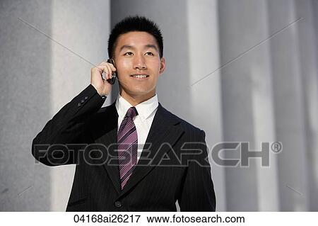 Businessman smiling, talking on phone View Large Photo Image Stock Photo - Businessman smiling, talking on phone. Fotosearch