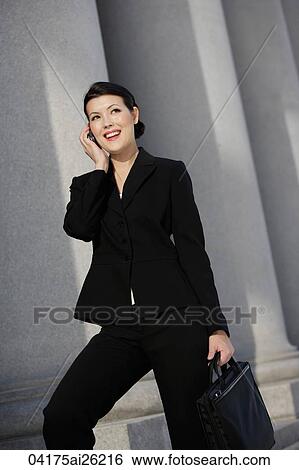 Stock Photograph - Businesswoman smiling, talking on phone. Fotosearch