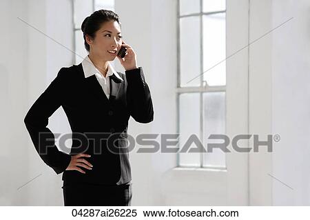 Businesswoman using mobile phone, hands on hip View Large Photo Image Stock Photography - Businesswoman using mobile phone, hands on hip. Fotosearch