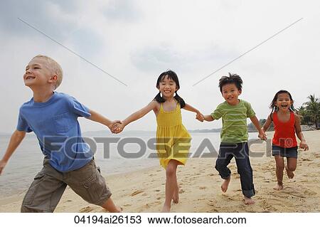 Four kids running down the beach holding hands. View Large Photo Image Stock Image - Four kids running down the beach holding hands.. Fotosearch