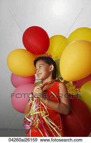 Stock Photo - Girl holding balloons looking away.. Fotosearch