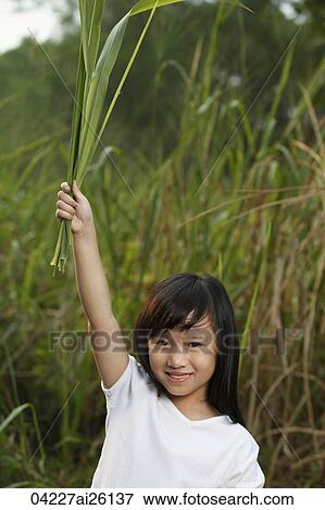 Girl holding leaves in air. View Large Photo Image Stock Photo - Girl holding leaves in air.. Fotosearch