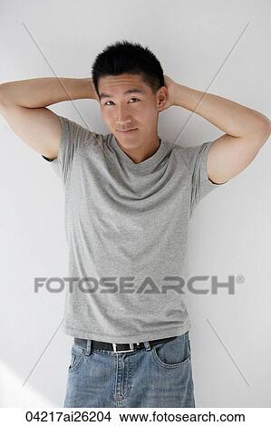 Picture - Man leaning casually against a wall. Fotosearch