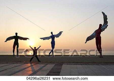 Man looking at statues along the coast at sunset in Shenzhen, China View Large Photo Image Stock Image - Man looking at statues along the coast at sunset in Shenzhen, China. Fotosearch