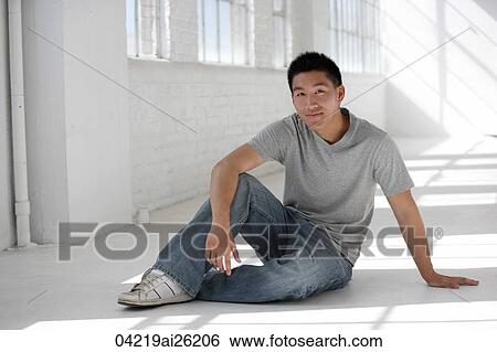 Man sitting casually on the floor View Large Photo Image Stock Photograph - Man sitting casually on the floor. Fotosearch