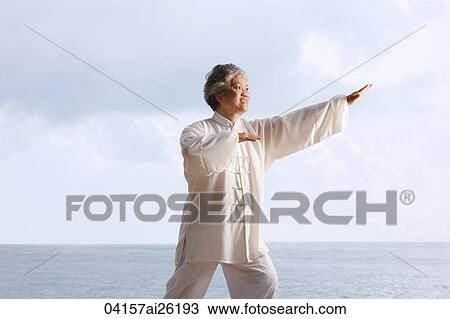 Stock Image - Older woman doing tai chi.. Fotosearch