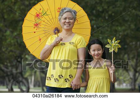 Older woman with young girl holding a pinwheel. View Large Photo Image Picture - Older woman with young girl holding a pinwheel.. Fotosearch
