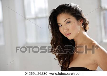 Stock Image - Portrait of young woman with long hair. Fotosearch