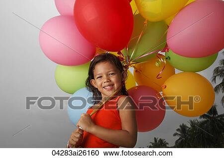 Smiling girl holding balloons. View Large Photo Image Stock Image - Smiling girl holding balloons.. Fotosearch