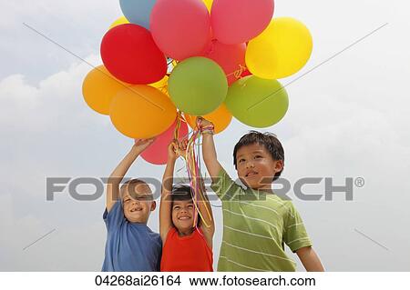 Picture - Three children holding balloons.. Fotosearch