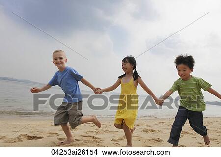Three children running while holding hands. View Large Photo Image Picture - Three children running while holding hands.. Fotosearch