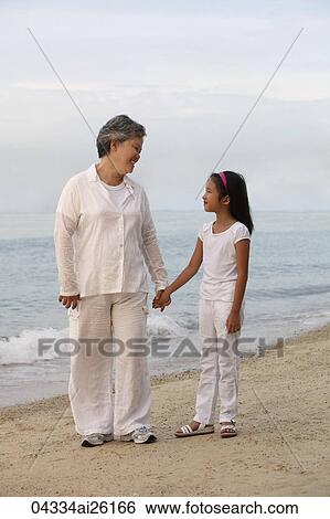 Stock Photograph - Woman holding young girl's hand.. Fotosearch
