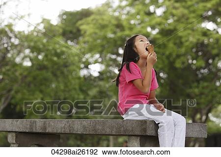 Young girl eating ice cream. View Large Photo Image Stock Image - Young girl eating ice cream.. Fotosearch
