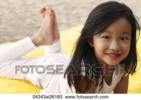 Young girl laying on stomach. View Large Photo Image Stock Image - Young girl laying on stomach.. Fotosearch