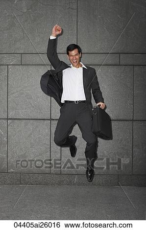 Stock Photograph - "businessman holding briefcase, jumping with arm raised". Fotosearch