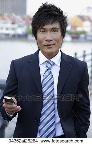 Businessman holding cell phone View Large Photo Image Picture - Businessman holding cell phone. Fotosearch