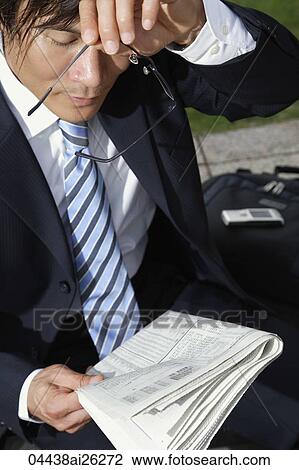 Businessman holding glasses and paper View Large Photo Image Stock Image - Businessman holding glasses and paper. Fotosearch