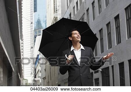 "businessman holding umbrella, looking up into the sky" View Large Photo Image Stock Photo - "businessman holding umbrella, looking up into the sky". Fotosearch