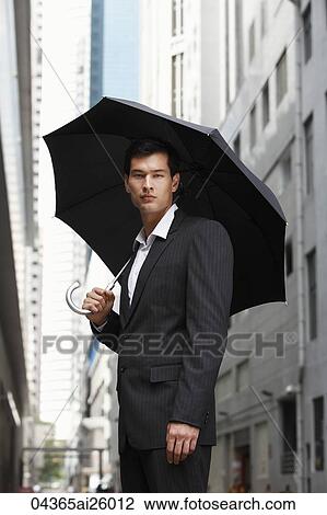 Stock Image - businessman holding umbrella. Fotosearch