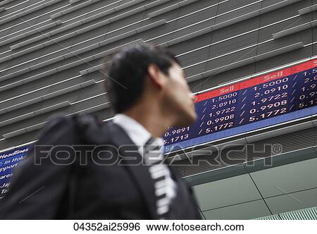 Stock Photograph - businessman in a suit looking at stock exchange. Fotosearch