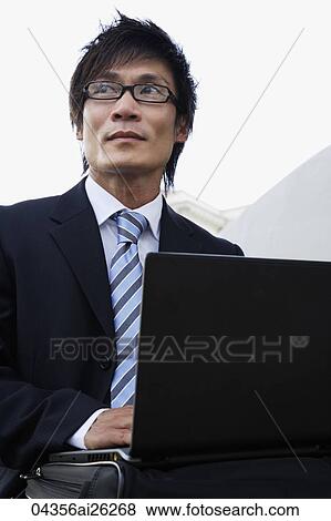 Businessman outside with laptop View Large Photo Image Stock Photo - Businessman outside with laptop. Fotosearch