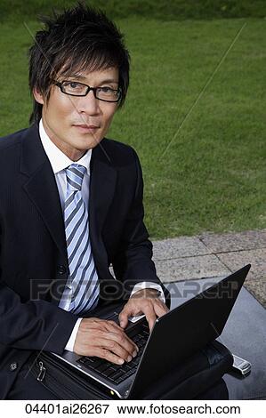 Stock Photo - Businessman outside with laptop. Fotosearch