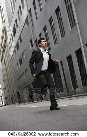 Stock Image - businessman running down street. Fotosearch