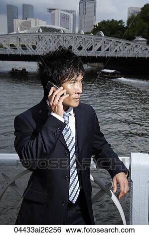 Businessman talking on cell phone outside View Large Photo Image Stock Photograph - Businessman talking on cell phone outside. Fotosearch