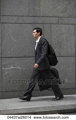 "businessman walking holding briefcase, carrying back pack" View Large Photo Image Picture - "businessman walking holding briefcase, carrying back pack". Fotosearch