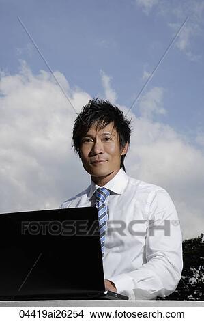 Businessman working on laptop outdoors View Large Photo Image Picture - Businessman working on laptop outdoors. Fotosearch