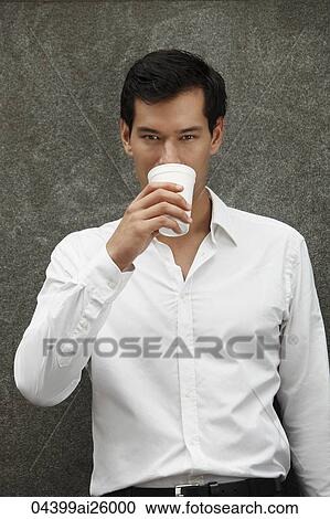Stock Image - man in white shirt drinking coffee. Fotosearch