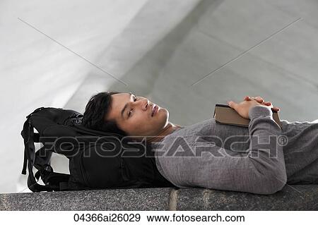 man laying down head resting on back pack View Large Photo Image Stock Photo - man laying down head resting on back pack. Fotosearch