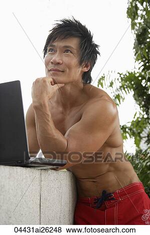 "Man outside with laptop, wearing swim trunks" View Large Photo Image Stock Photo - "Man outside with laptop, wearing swim trunks". Fotosearch