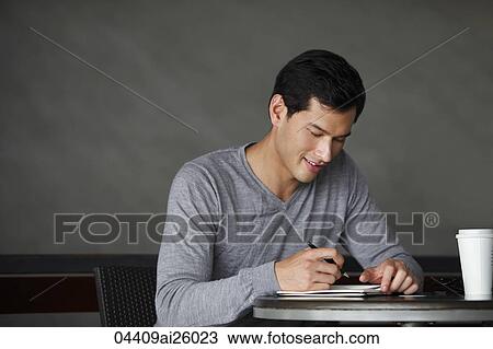 Stock Image - "man writing in a book, smiling slightly". Fotosearch