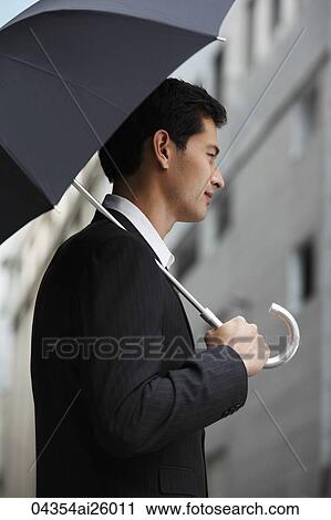 side profile of businessman holding umbrella View Large Photo Image Stock Image - side profile of businessman holding umbrella. Fotosearch