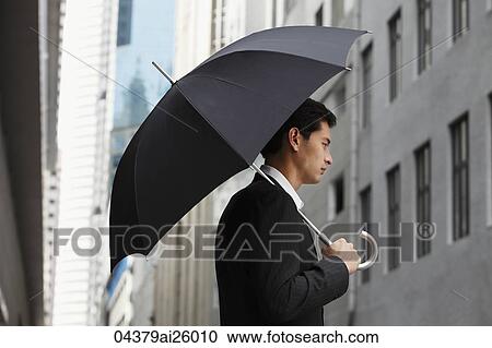 side profile of businessman holding umbrella View Large Photo Image Stock Image - side profile of businessman holding umbrella. Fotosearch