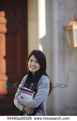 Chinese woman holding books in front of University. View Large Photo Image Stock Photo - Chinese woman holding books in front of University.. Fotosearch