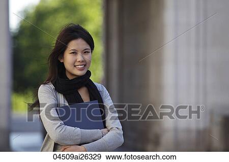 Chinese woman holding folder outside. View Large Photo Image Stock Photo - Chinese woman holding folder outside.. Fotosearch