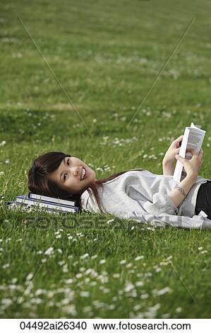Chinese woman laying on grass reading a book. View Large Photo Image Stock Image - Chinese woman laying on grass reading a book.. Fotosearch