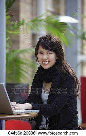 Chinese woman working on laptop at a cafe. View Large Photo Image Stock Photograph - Chinese woman working on laptop at a cafe.. Fotosearch