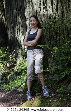 Woman resting against giant tree trunk View Large Photo Image Stock Photography - Woman resting against giant tree trunk. Fotosearch