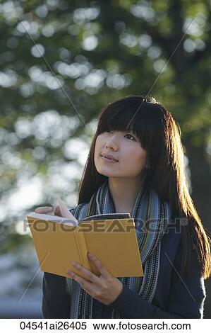 Asian woman holding book and looking up. View Large Photo Image Stock Photography - Asian woman holding book and looking up.. Fotosearch