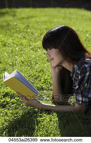Asian woman laying on grass reading a book. View Large Photo Image Stock Photo - Asian woman laying on grass reading a book.. Fotosearch