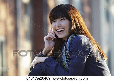 Asian woman smiling and talking on phone View Large Photo Image Stock Photo - Asian woman smiling and talking on phone. Fotosearch