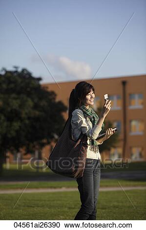 Asian woman smiling and talking on phone, outside. View Large Photo Image Stock Image - Asian woman smiling and talking on phone, outside.. Fotosearch
