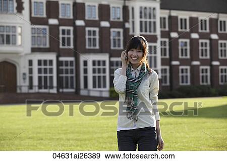 Stock Photo - Asian woman talking on phone outside.. Fotosearch