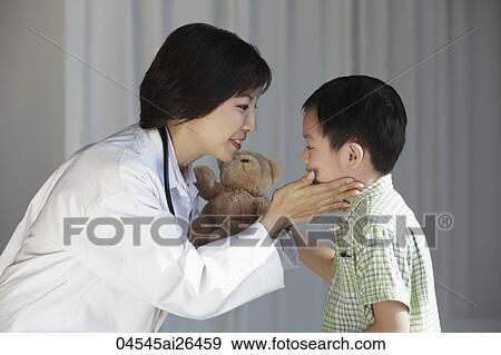 Doctor comforting young boy View Large Photo Image Stock Photo - Doctor comforting young boy. Fotosearch
